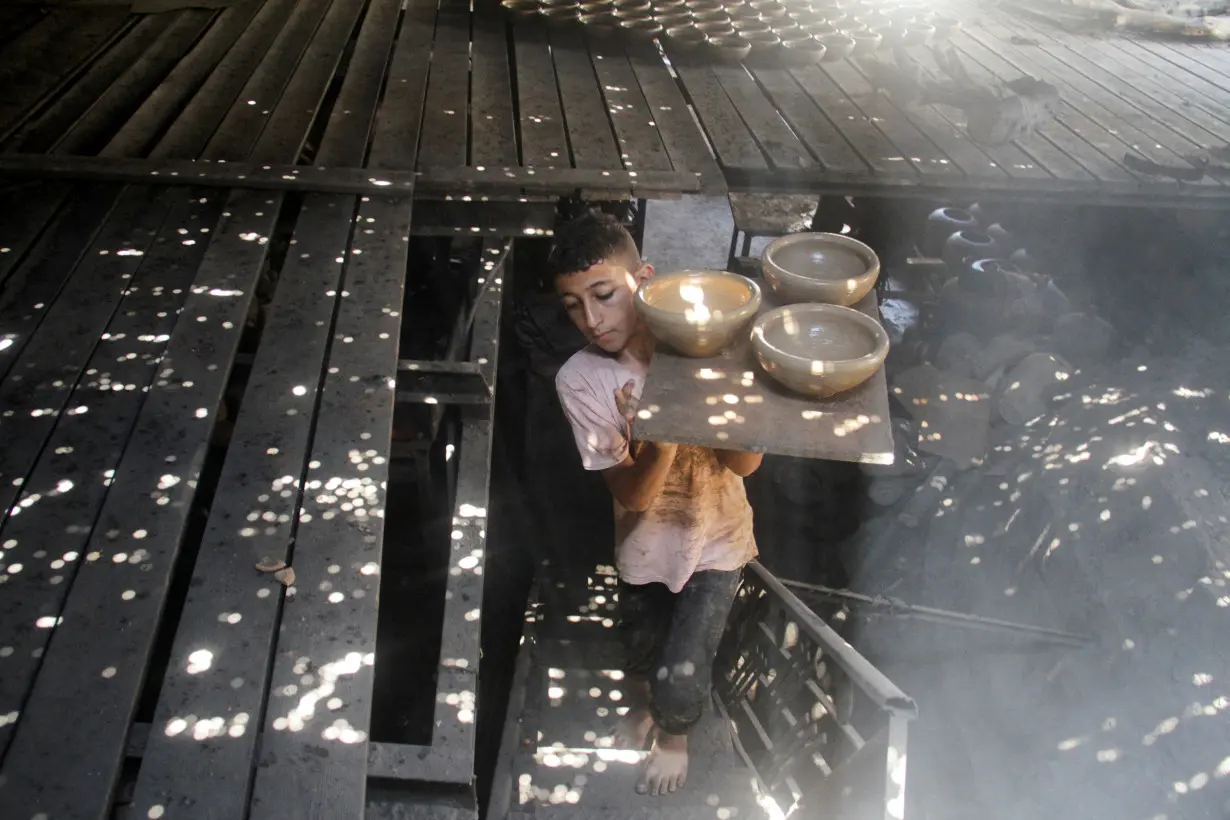 Palestinians work in a pottery workshop, in Gaza City