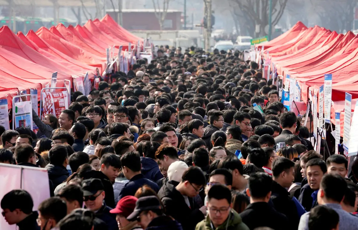 FILE PHOTO: Job seekers crowd a job fair at Liberation Square in Shijiazhuang