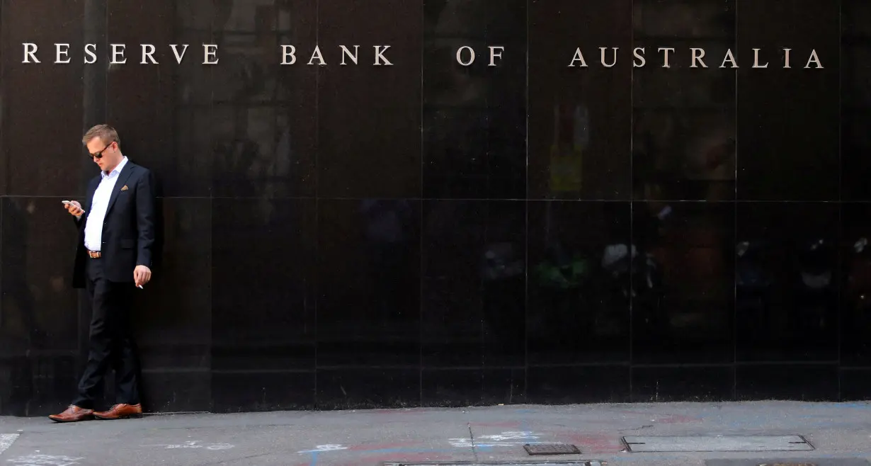 FILE PHOTO: A man smokes next to the Reserve Bank of Australia headquarters in central Sydney