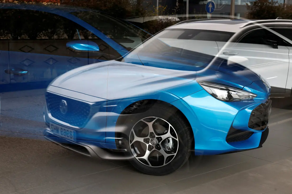 FILE PHOTO: FILE PHOTO: MG Motor vehicles are seen reflected in the glass of a car showroom in Santander,