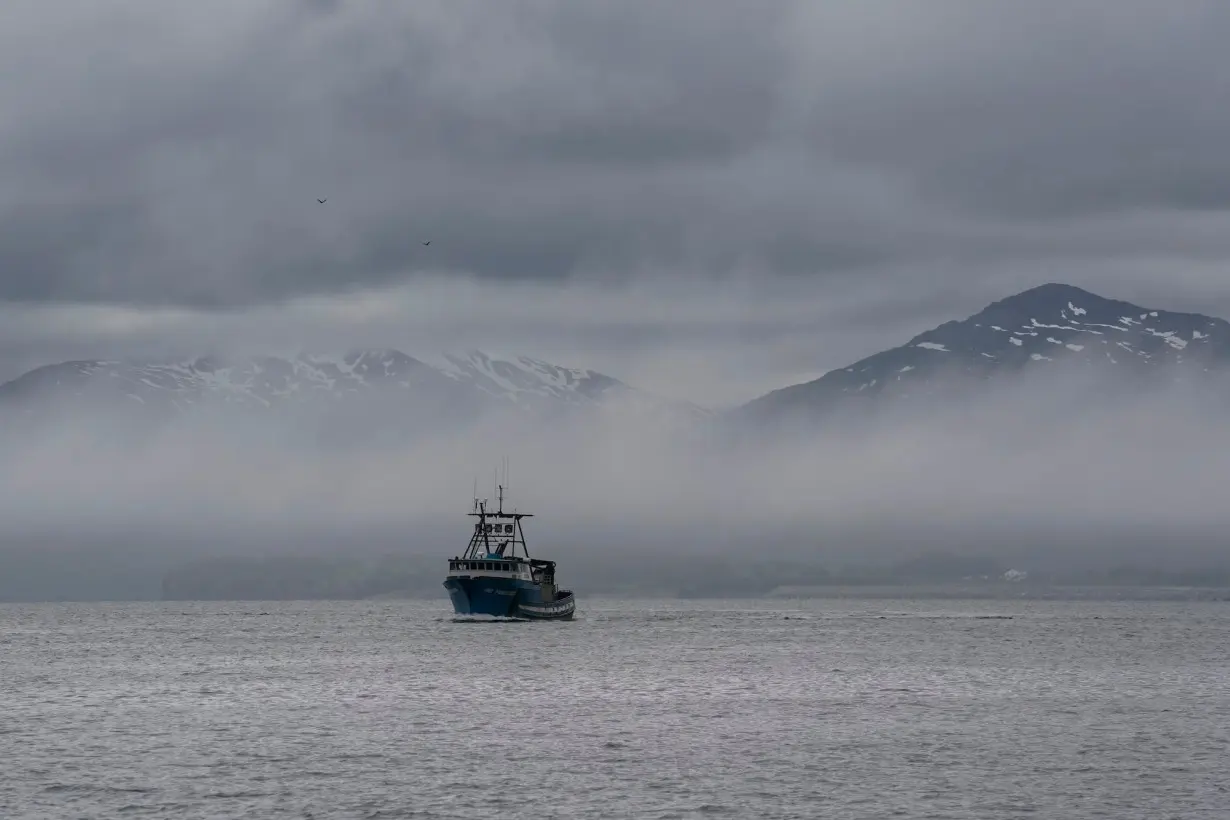 A boat in front of the snow-covered mountains in Kodiak, Alaska, in June 2023.