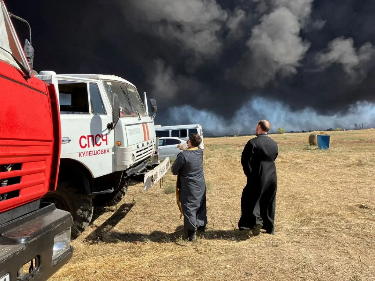 Russian priests bring icon to try to tame depot fire after drone attack