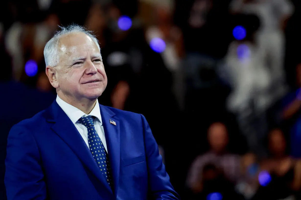 Tim Walz prepares to introduce himself, helped by football players, students and Amy Klobuchar