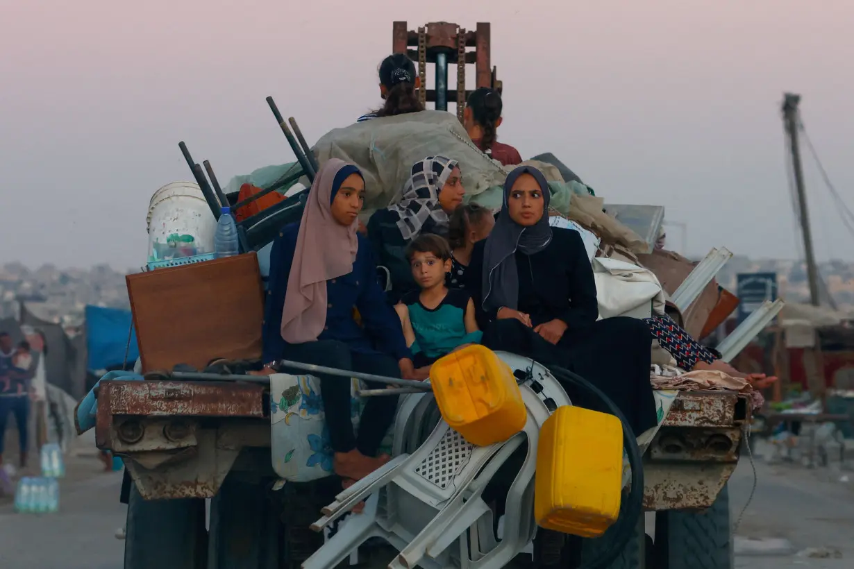 Displaced Palestinians make their way after fleeing the western part of Khan Younis, following an evacuation order by the Israeli army