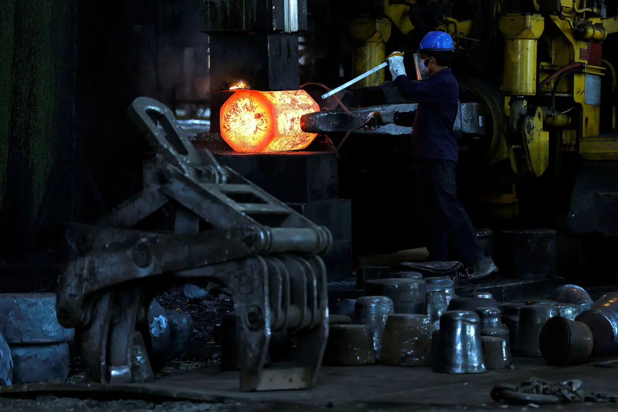 FILE PHOTO: An employee moves forging red hot steel inside a factory in West Bengal