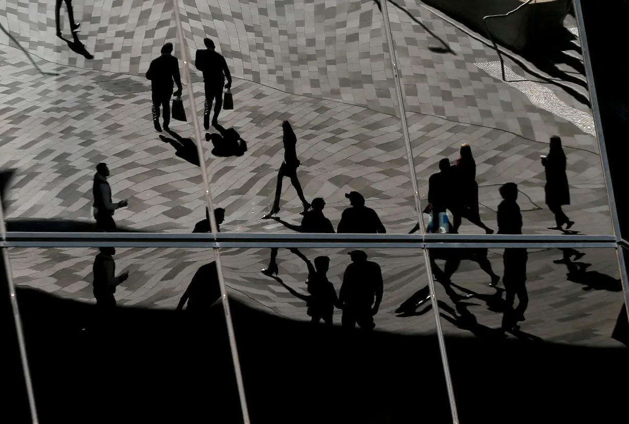 FILE PHOTO: Workers are reflected in an office building's windows in Sydney's Barangaroo business district in Australia's largest city