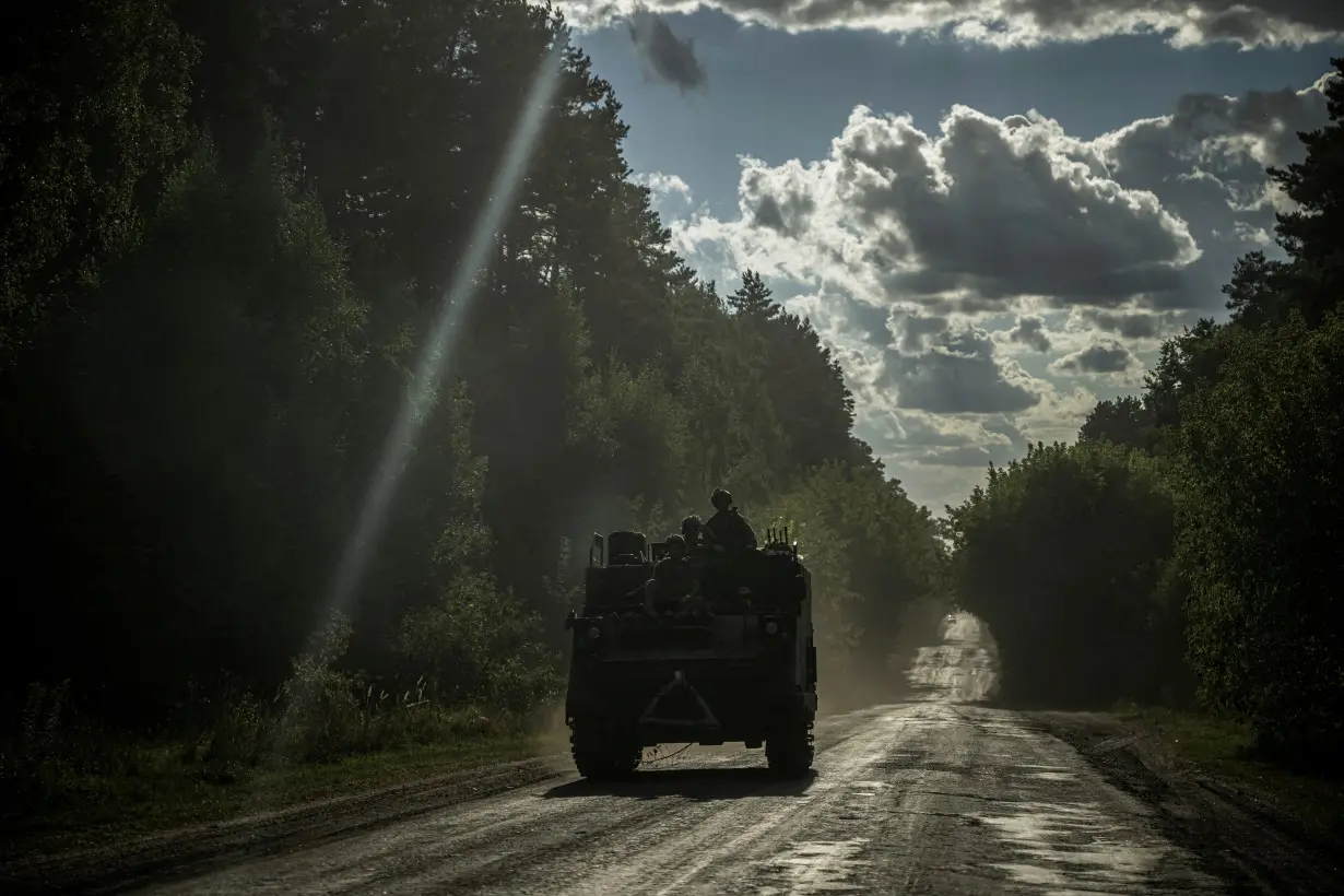 FILE PHOTO: Ukrainian servicemen ride a military vehicle near the Russian border in Sumy region