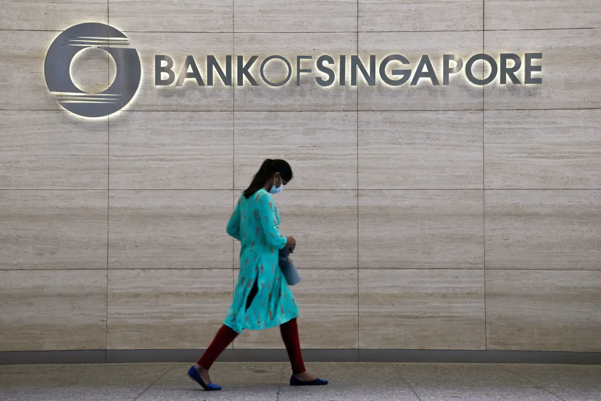 Woman walks past a Bank of Singapore office in Singapore