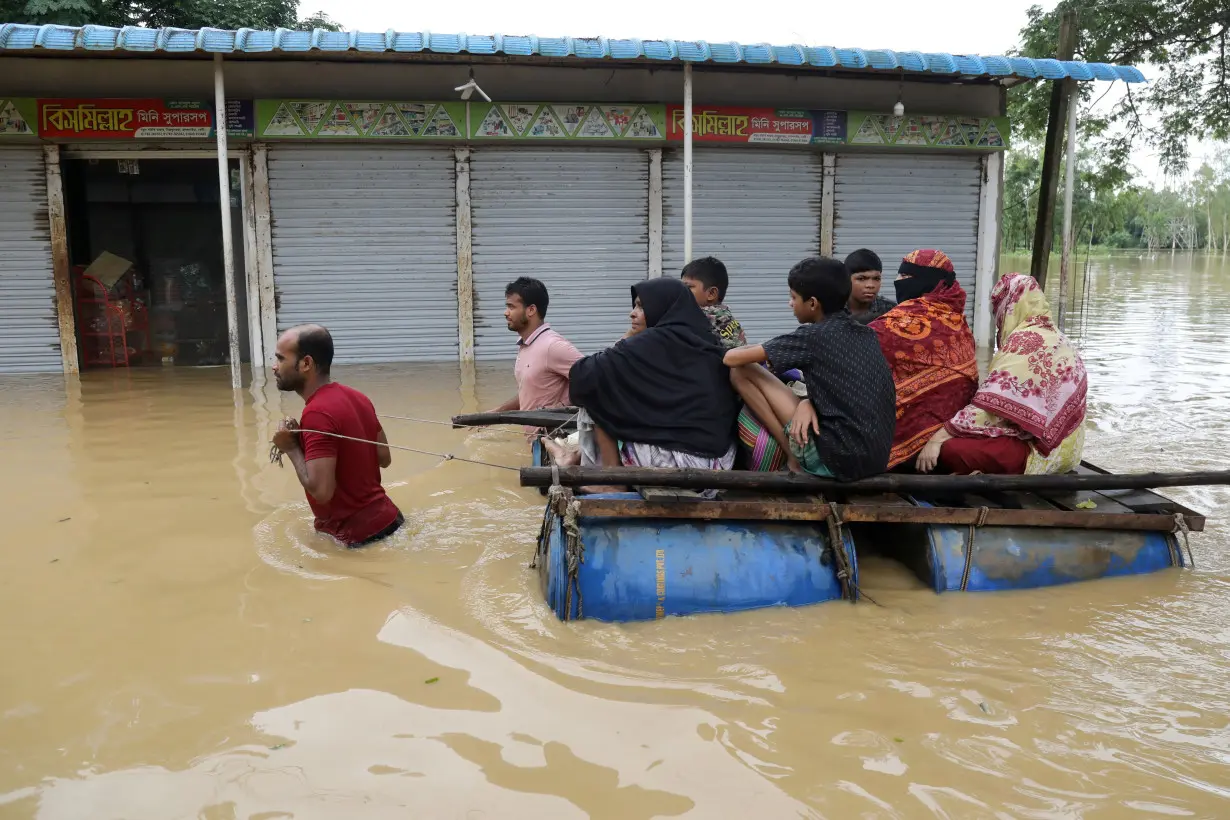 Flood-affected people move to a safe place after several districts flooded, at Chhagalnaiya in Feni