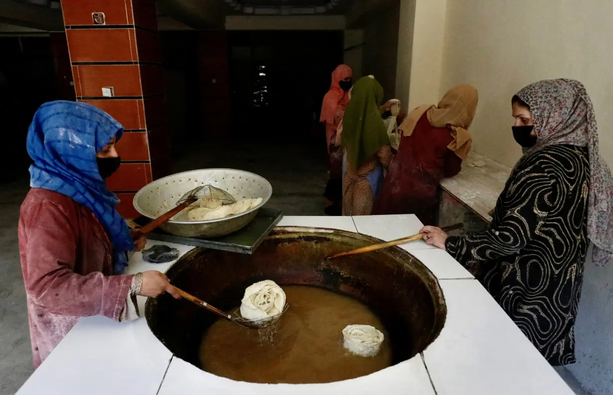 FILE PHOTO: Afghan women fry traditional cookies inside a bakery, in Kabul