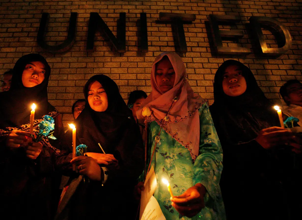 FILE PHOTO: Thai-Muslim student hold a candle light vigil for victims of the Tak Bai shooting on it's third anniversary outside the United Nation building in Bangkok