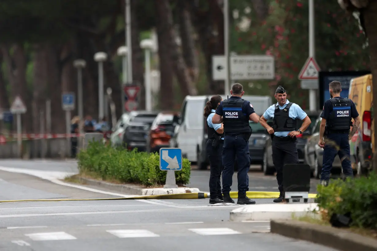 French police stand guard after cars were set on fire in front of the city's synagogue, in La Grande-Motte