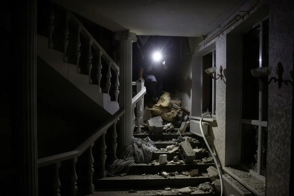 A man walks among debris inside the hotel targeted by a Russian missile.