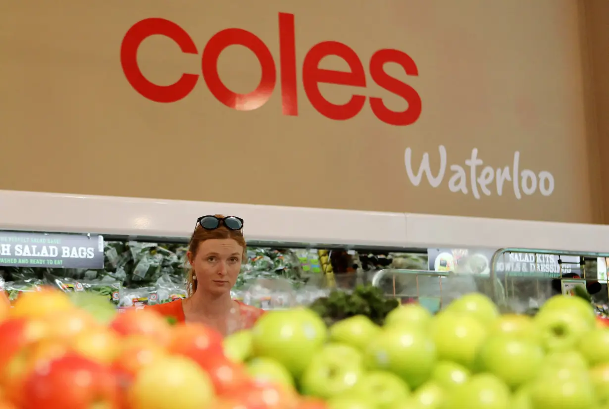 FILE PHOTO: A woman walks in the fruit and vegetables section at a Coles supermarket (main Wesfarmers brand) in Sydney