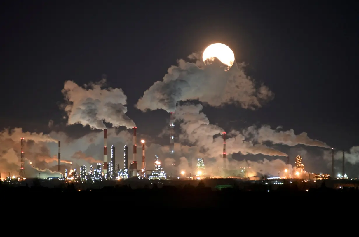 FILE PHOTO: A full moon rises over Gazprom Neft's oil refinery in Omsk