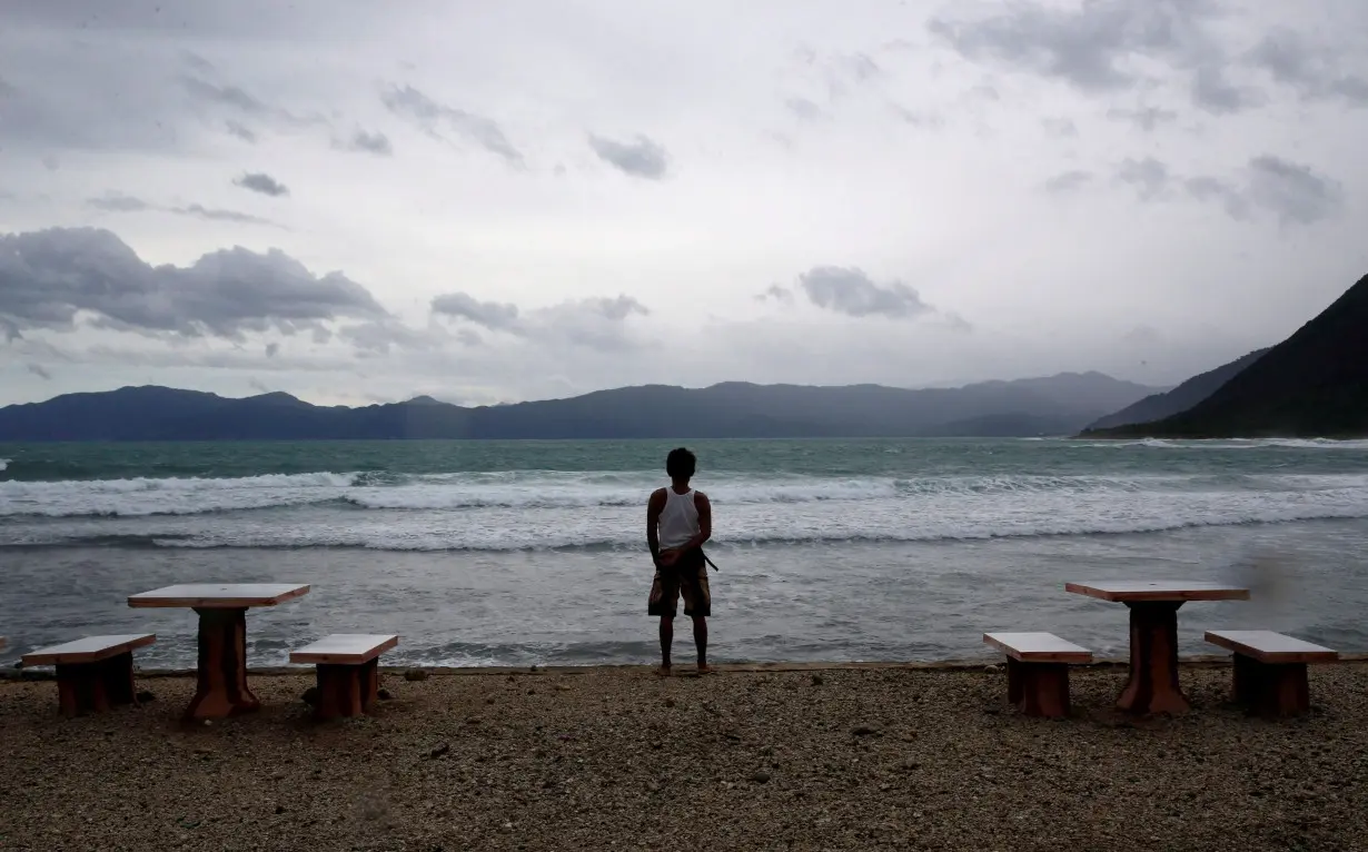 FILE PHOTO: A resort worker looks out at a beach at an empty resort as Typhoon Haima strikes Pagudpud