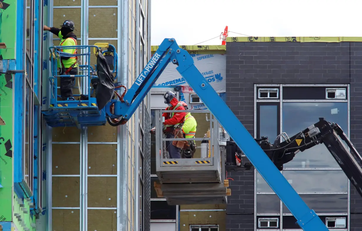 FILE PHOTO: Construction workers work on a new apartment building in Ottawa