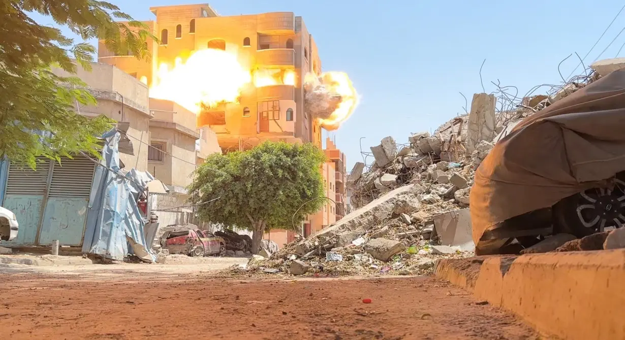 Smoke and flames rise from a house hit by an Israeli strike, amid the ongoing conflict between Israel and Hamas, in Nuseirat refugee camp, in the central Gaza Strip, in this still picture taken from a video