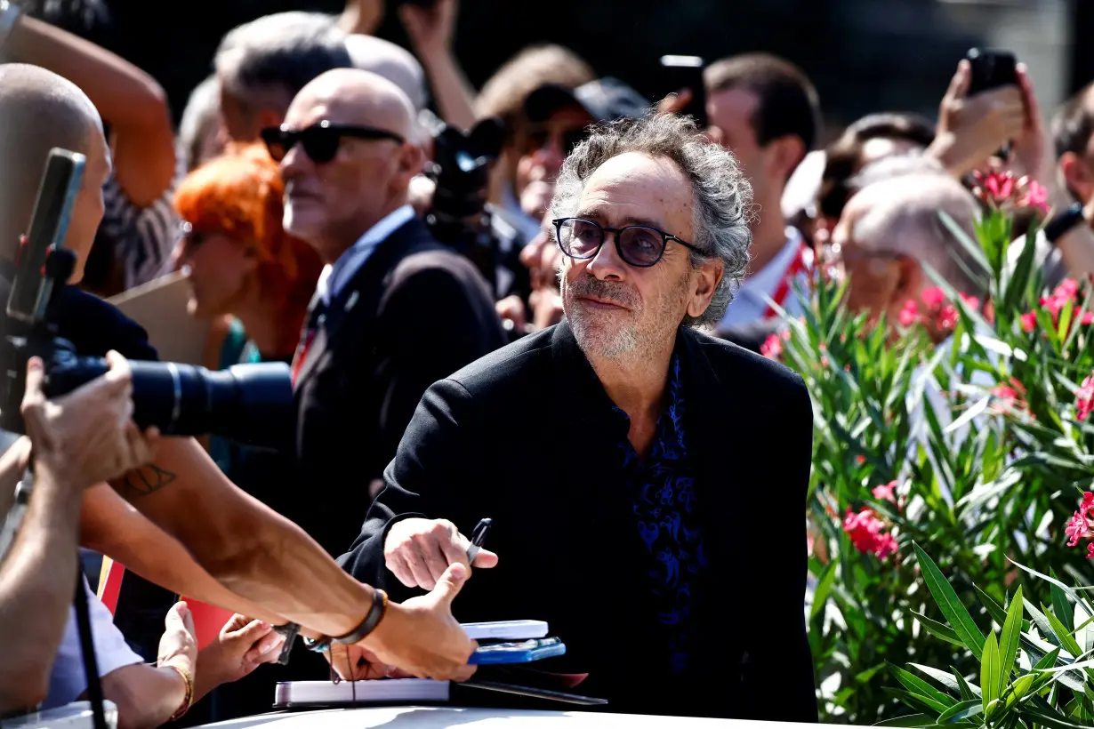 Director Tim Burton signs autographs on the day of a photocall for the film 