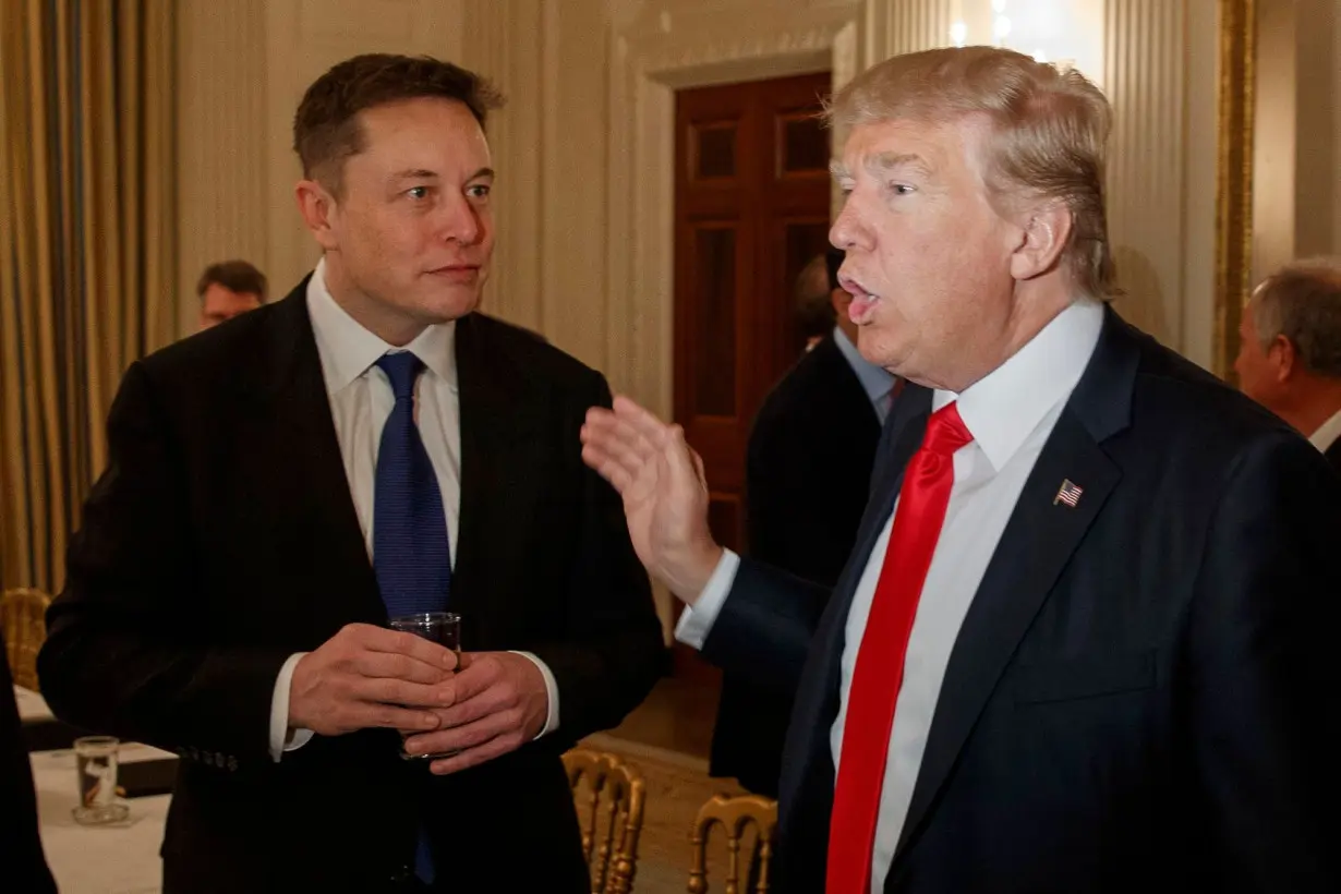 Then-President Donald Trump, right, talks with Tesla and SpaceX CEO Elon Musk at the White House in Washington, in February 2017. Musk officially acquired Twitter in October 2022.