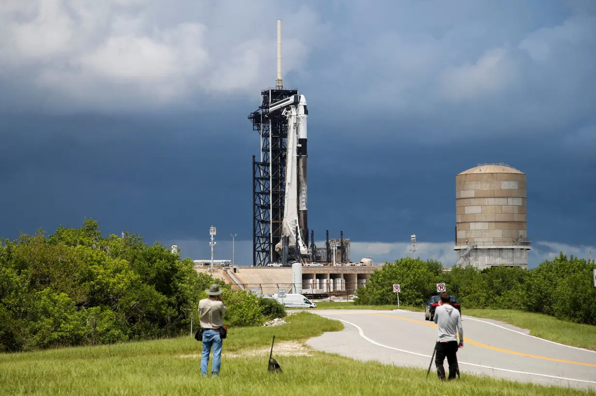 FILE PHOTO: A SpaceX Falcon 9 rocket is prepared for launch of Polaris Dawn, a private human spaceflight mission, as photographers look on at the Kennedy Space Center in Cape Canaveral,