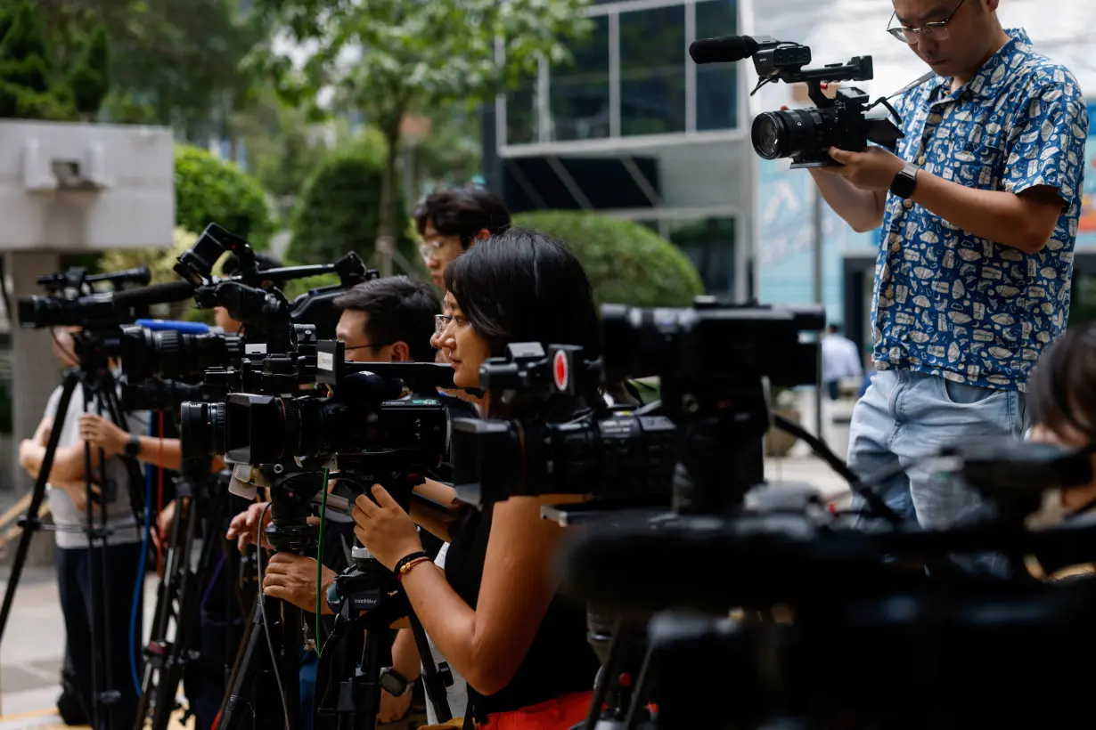 Members of the media work outside District Court ahead of the verdict in a landmark sedition trial against two former editors of now-shuttered online media Stand News, in Hong Kong