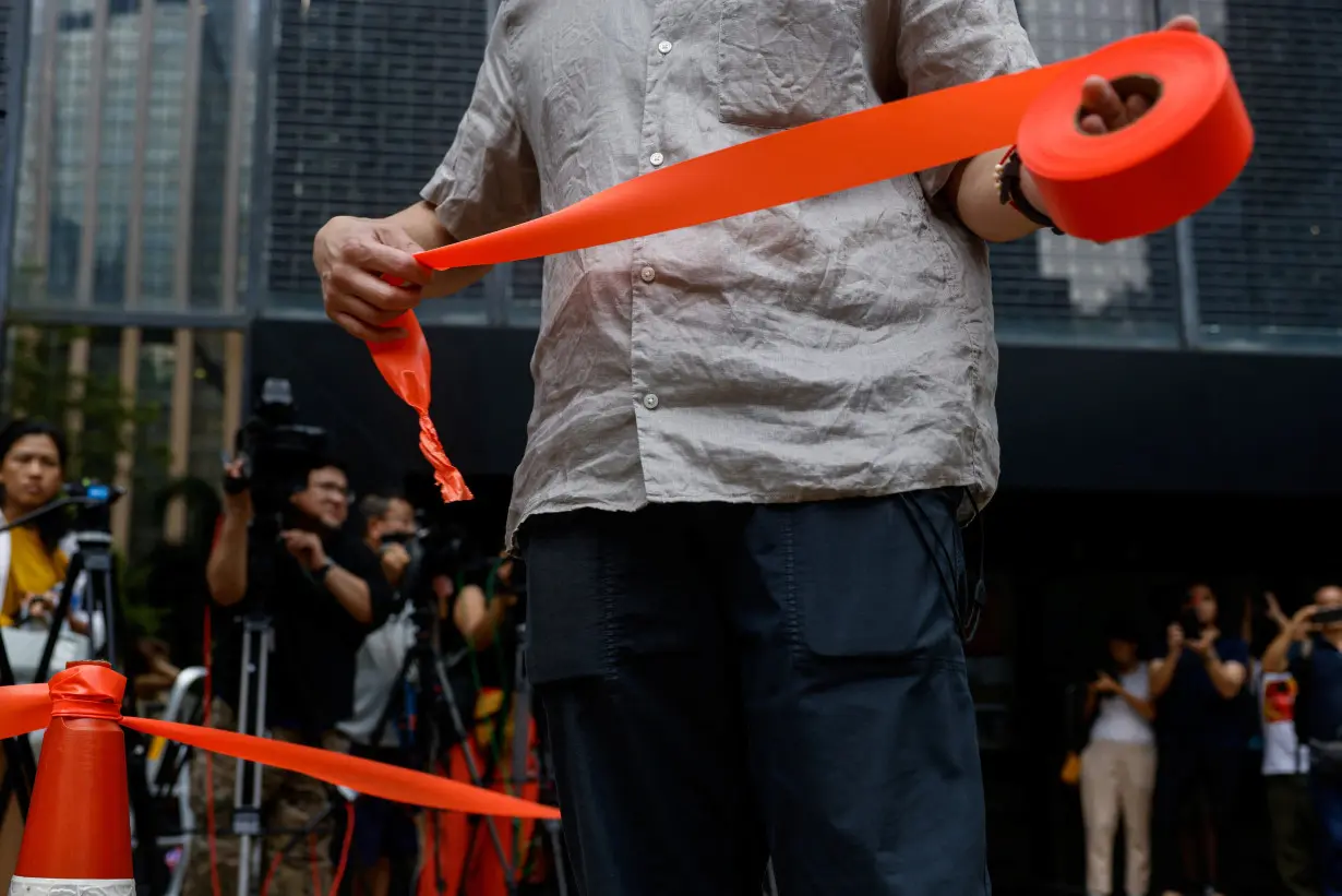 A police holds a cordon line outside District Court ahead of the verdict in a landmark sedition trial against two former editors of now-shuttered online media Stand News, in Hong Kong