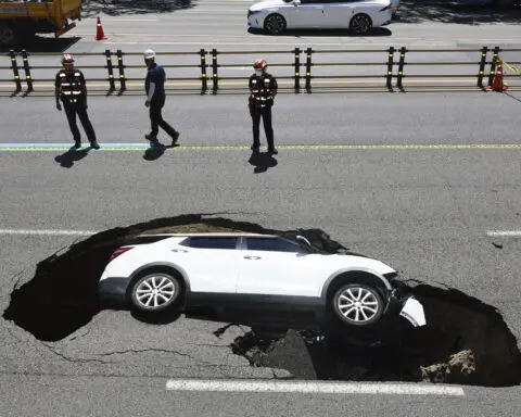 A sinkhole swallows an SUV in South Korea, injuring 2 people