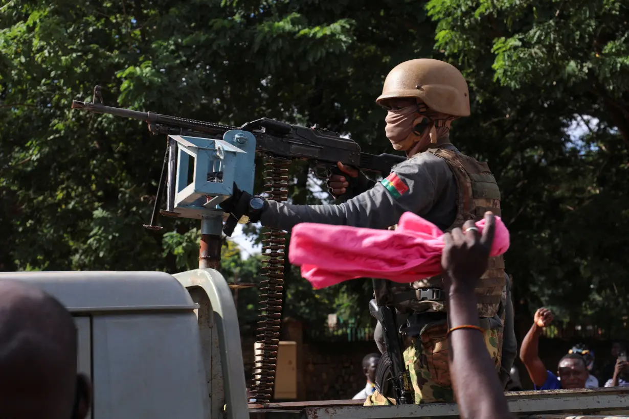 FILE PHOTO: New junta's soldiers stand guard in an armoured vehicle in Ouagadougou