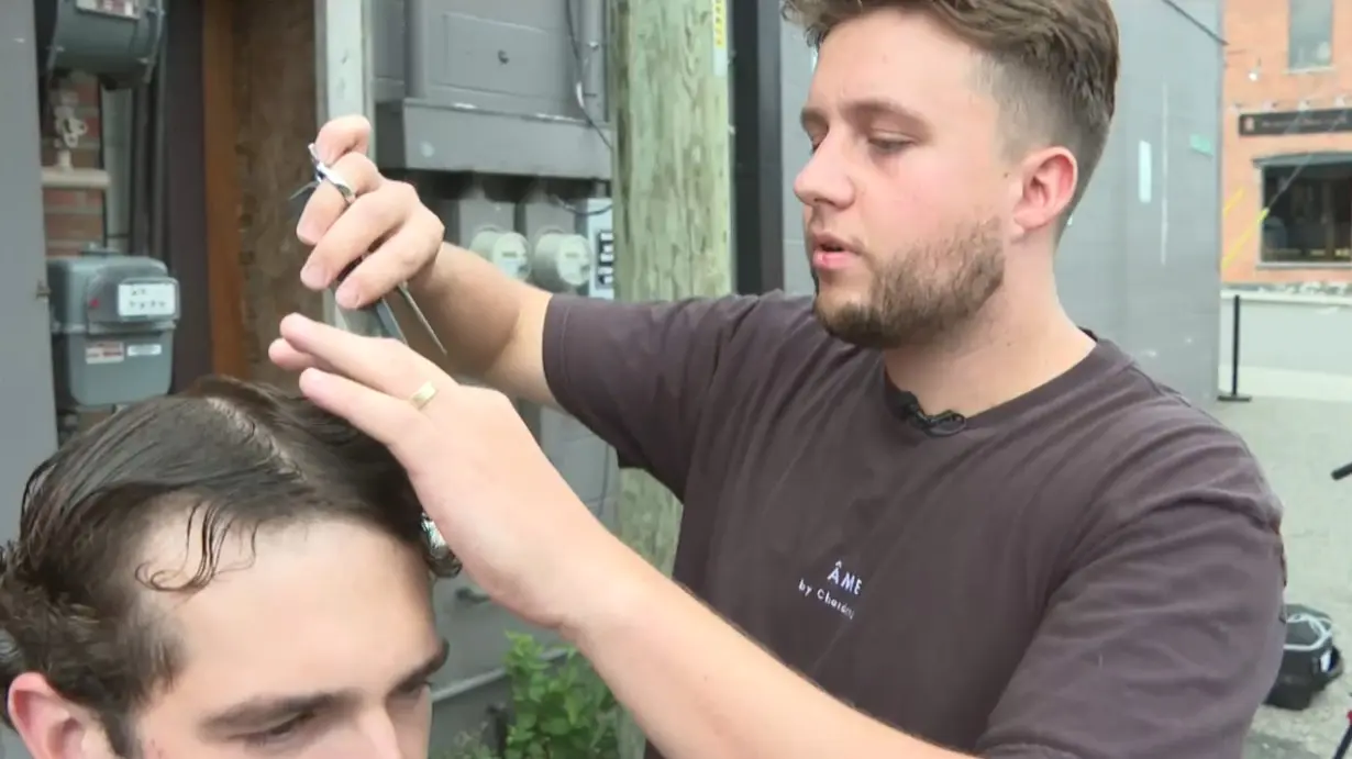 Barbershop cuts hair outside after storm knocks out power