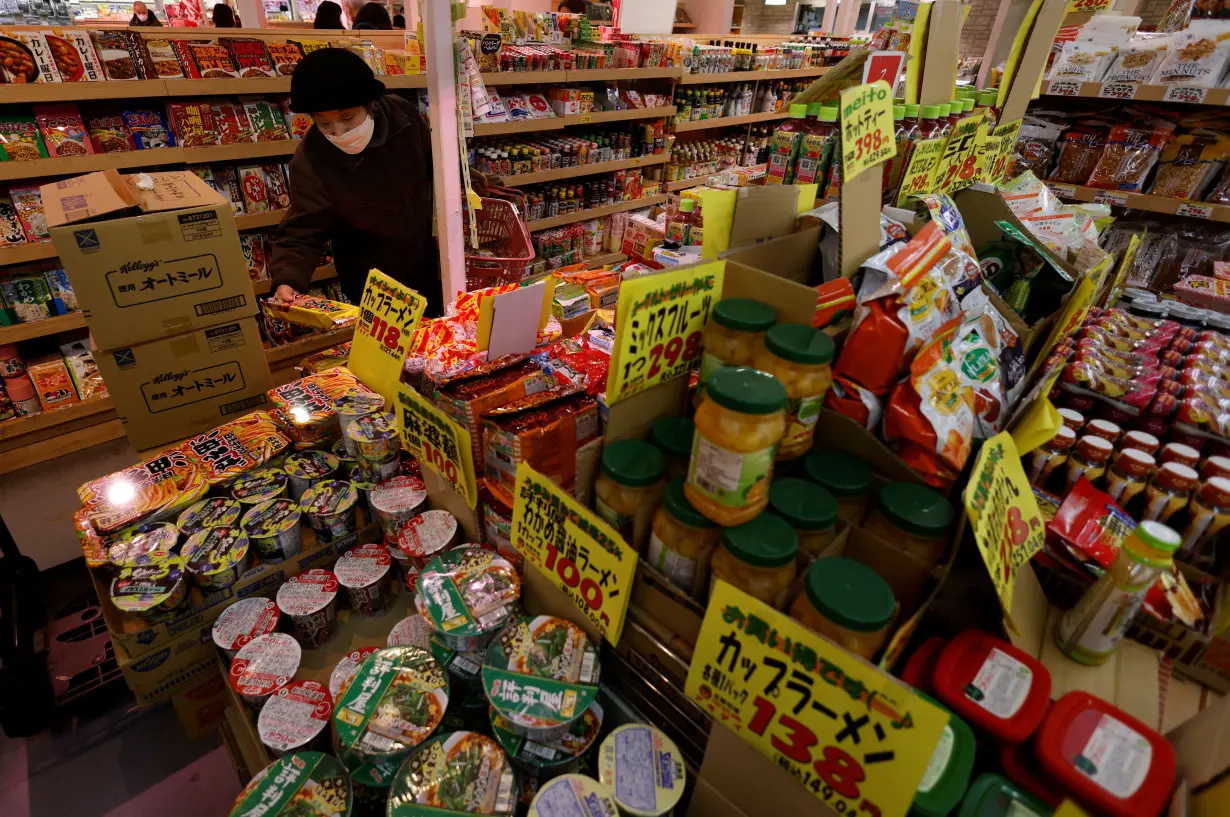 A shopper checks food items at a supermarket in Tokyo