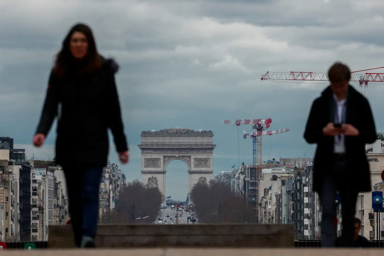 People walk on the esplanade of La Defense