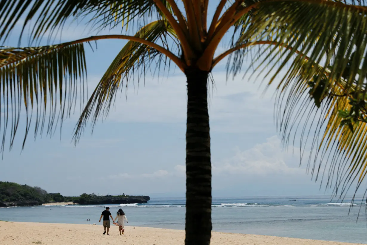 FILE PHOTO: Tourists enjoy the beach in Nusa Dua, Bali