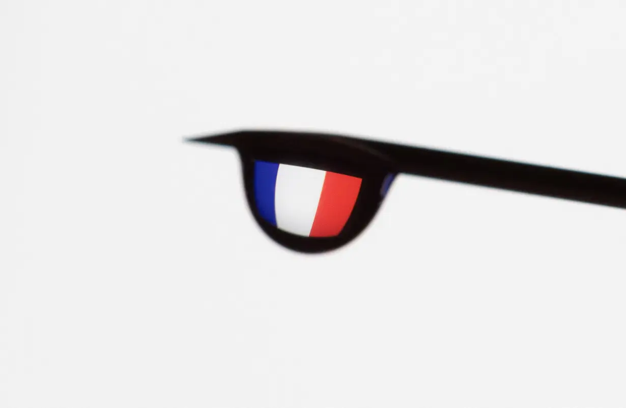 Illustration shows the flag of France reflected in a drop from a syringe needle