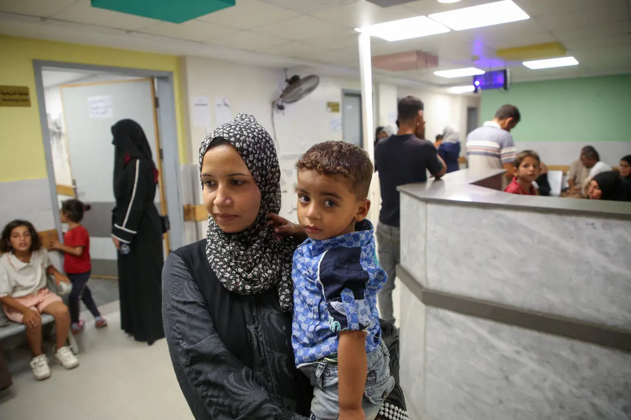 Palestinian children are examined by a doctor at Nasser hospital