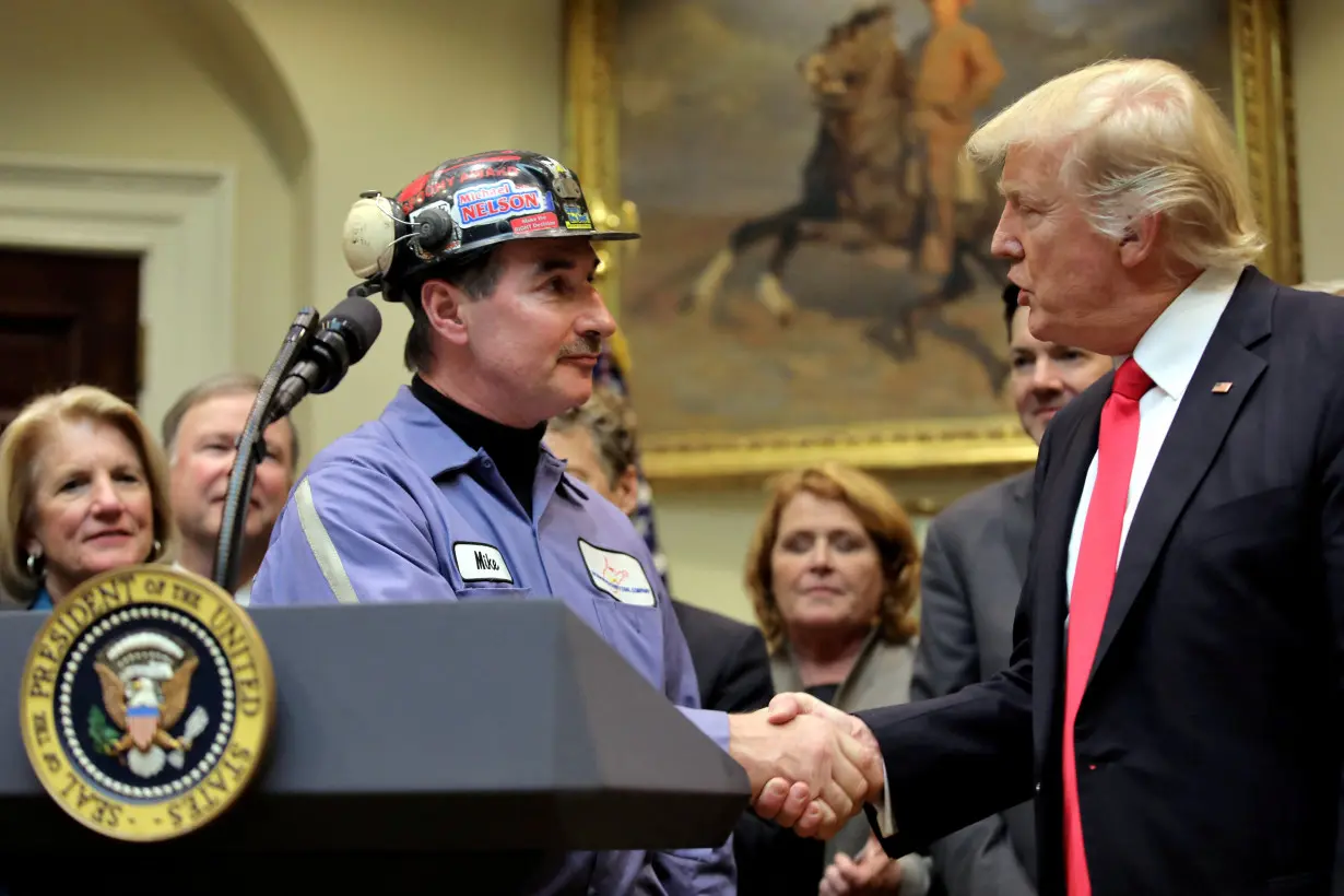 FILE PHOTO: Michael Nelson, a coal miner shakes hands with then-U.S. President Donald Trump as he prepares to sign Resolution 38, at the White House in Washington, U.S.