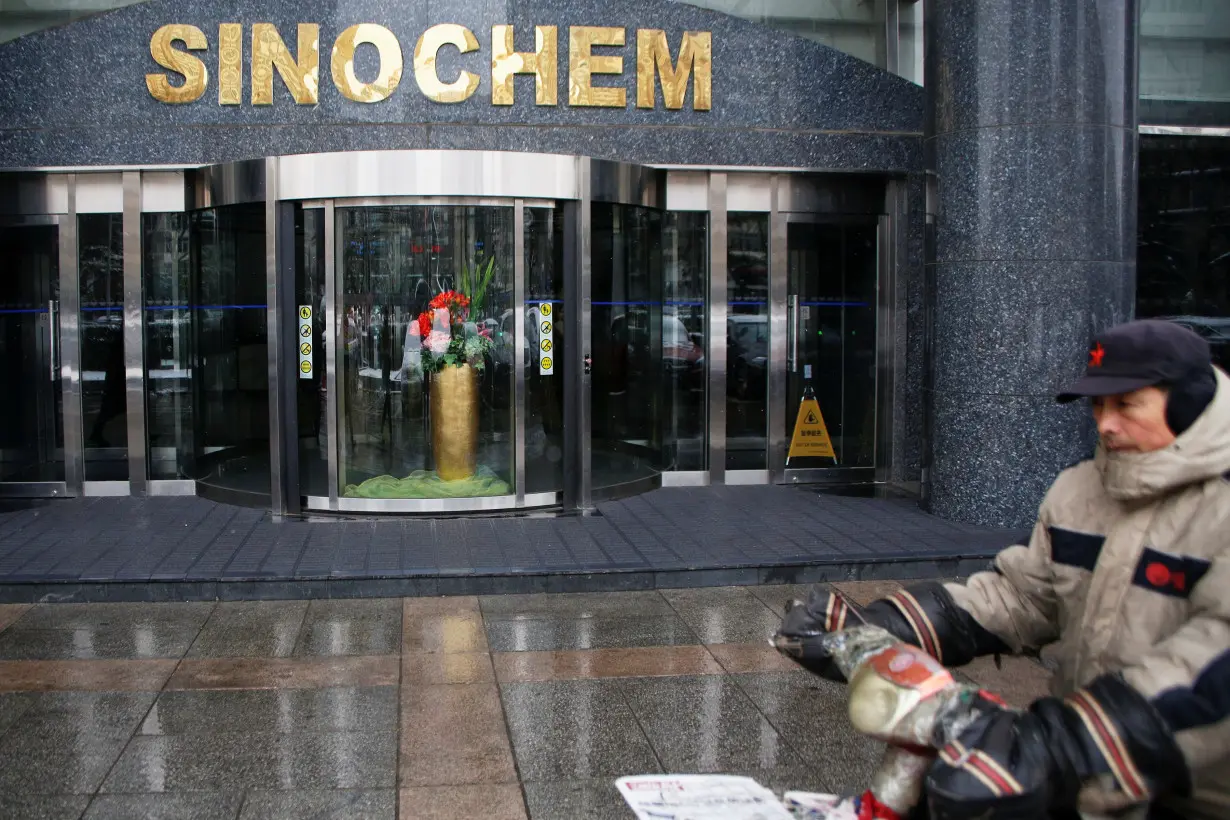 A man rides past the office building of Sinochem in Beijing