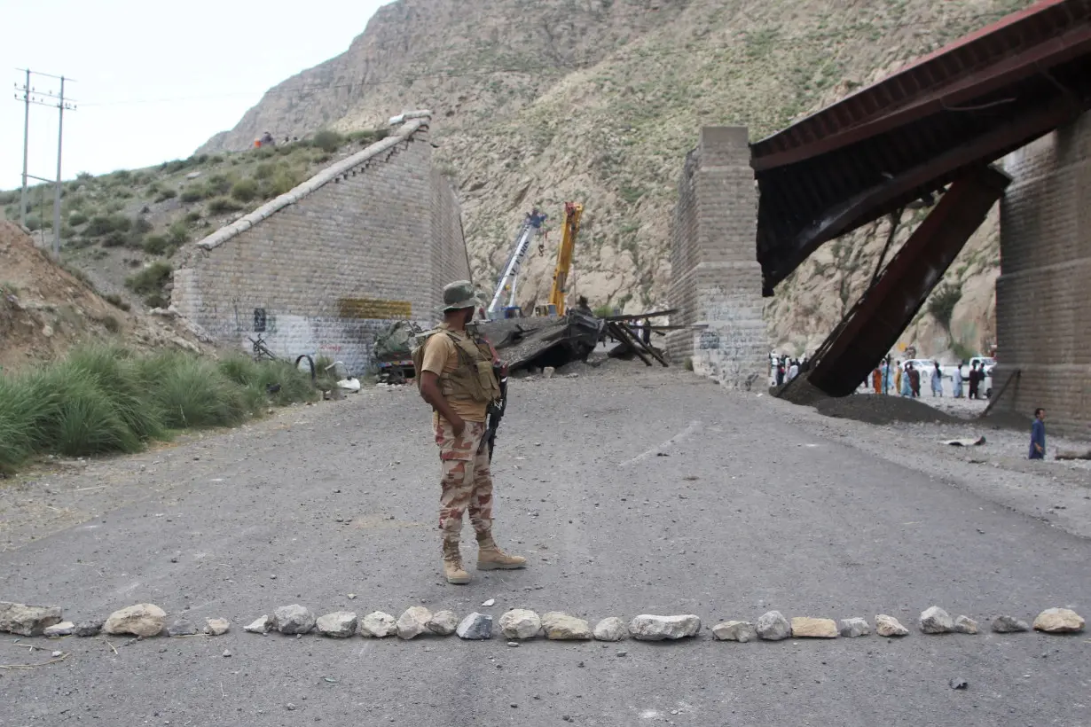 A paramilitary soldier stands on a road, as restoration works go on at damaged railway tracks, a day after separatist militants conducted deadly attacks, in Bolan district of Pakistan's restive province of Balochistan, Pakistan, August 27, 2024.