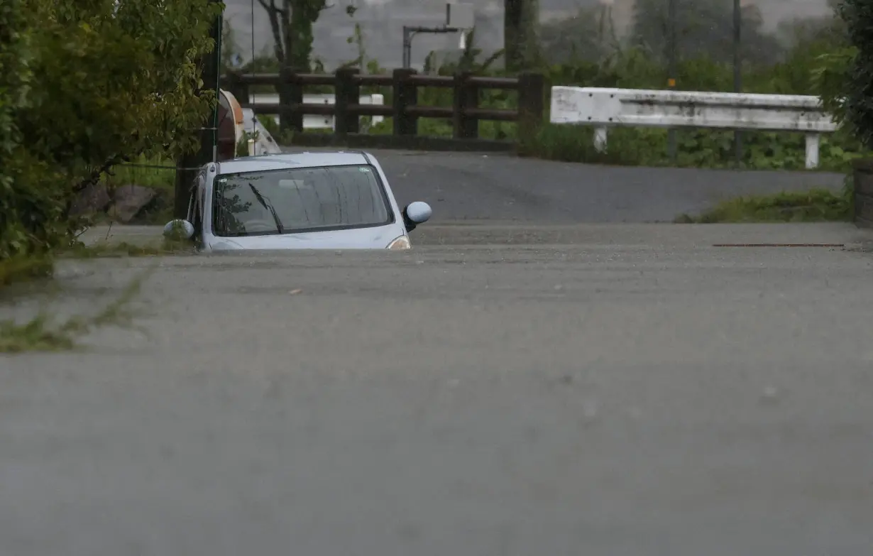 FILE PHOTO: A car is submerged at a flooded area due to heavy rains from Typhoon Shanshan in Yufu, Oita Prefecture, southwestern Japan