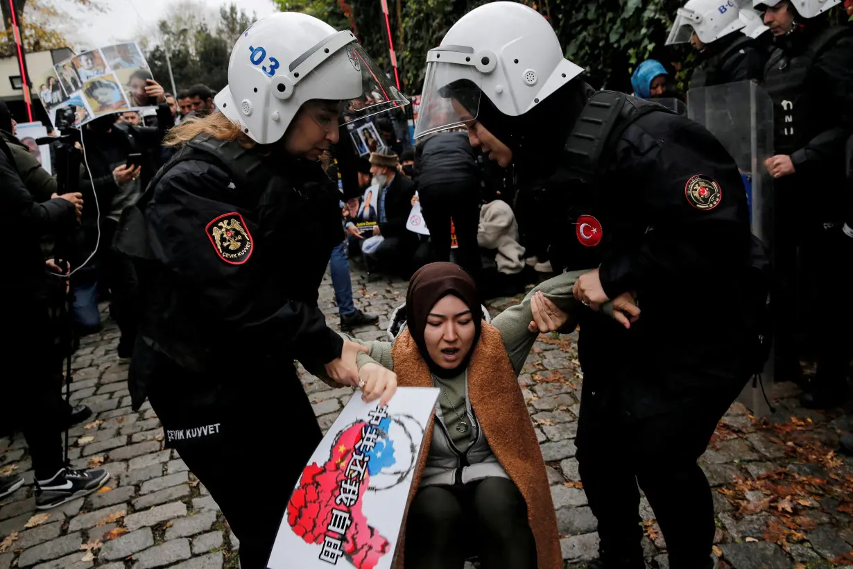 FILE PHOTO: Ethnic Uyghur demonstrators scuffle with riot police as they try to continue a sit-in protest against China