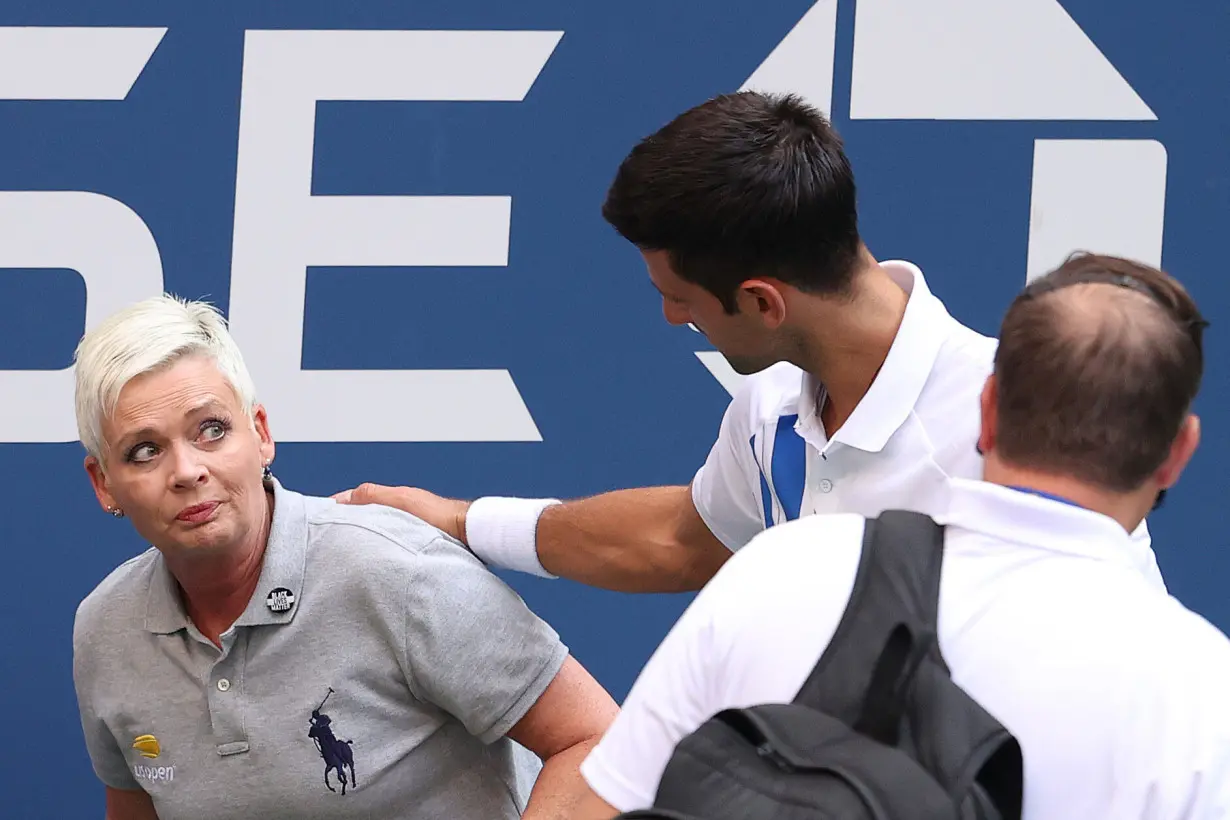 Novak Djokovic of Serbia tends to a line judge Laura Clark who was hit with the ball during his Men's Singles fourth round match against Pablo Carreno Busta of Spain on Day Seven of the 2020 US Open at the USTA Billie Jean King National Tennis Center on September 6, 2020 in the Queens borough of New York City.