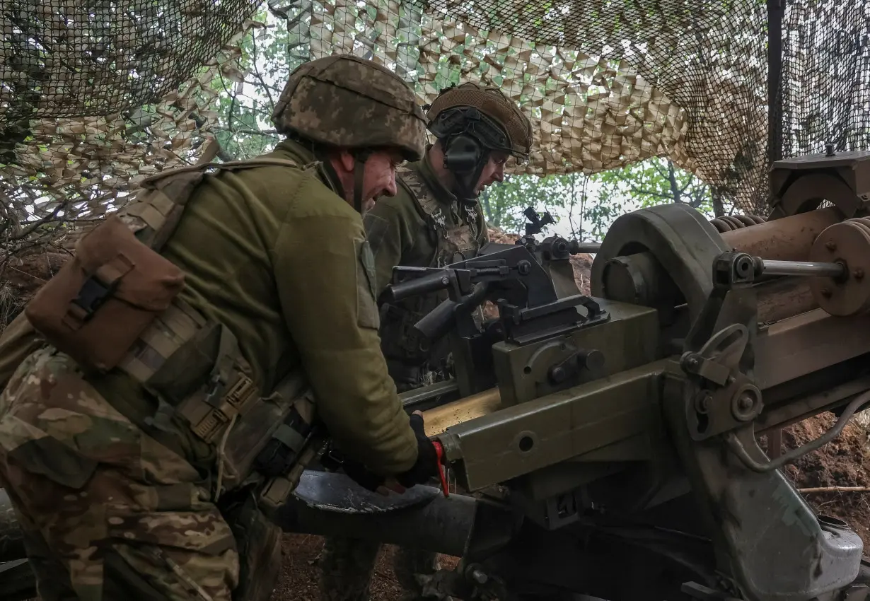 FILE PHOTO: Ukrainian service members fire a L119 howitzer in Donetsk region