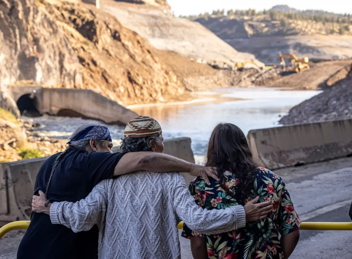 Tribal members hug as crews took down what was left of Iron Gate Dam on the Klamath River. A coalition of tribes, local and state authorities joined to make the years-long project a reality.