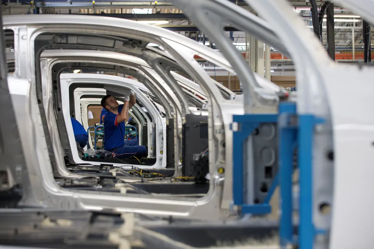 An employee works on the automobile assembly line of Bluecar electric city cars at Renault car maker factory in Dieppe, western France