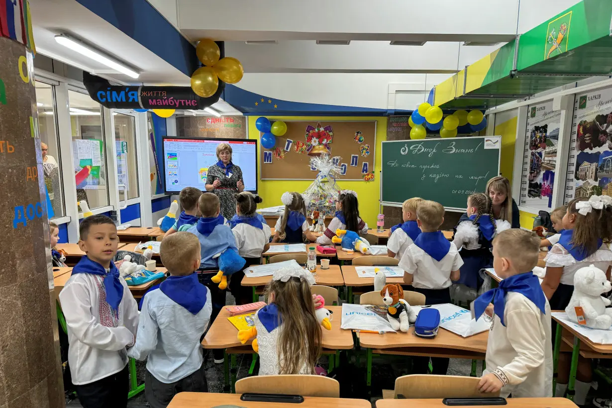 Teachers conduct a lesson for students on the first day of a school year at an underground school in Kharkiv