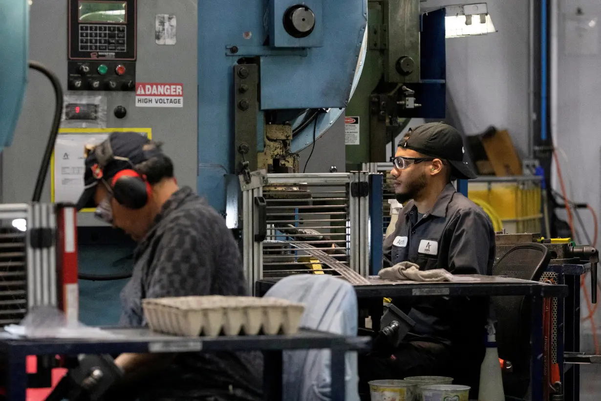 FILE PHOTO: Factory workers operate machine presses at Abipa Canada in Boisbriand