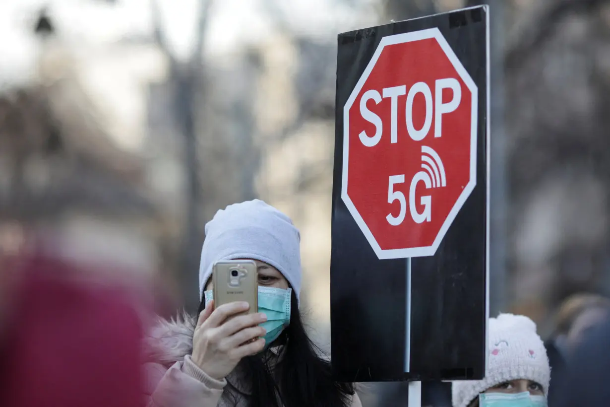 FILE PHOTO: A woman uses her mobile phone while holding a placard reading 