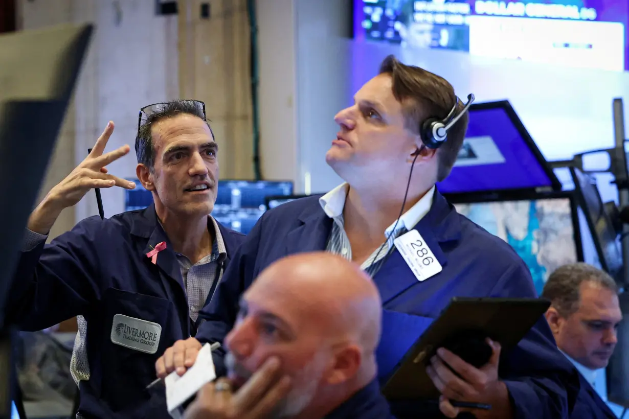 FILE PHOTO: Traders work on the floor of the NYSE in New York