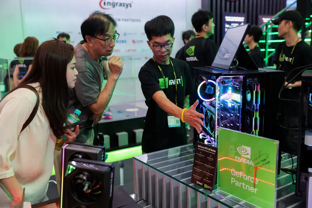 A staff introduce NVIDIA GeForce series equipment on display at Computex in Taipei