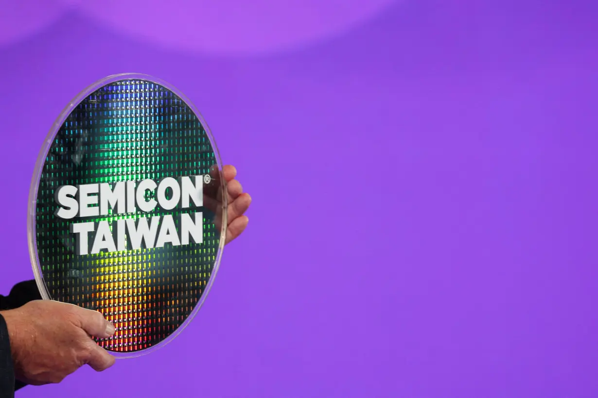 FILE PHOTO: A person holds a wafer at the Semicon Taiwan exhibition show in Taipei